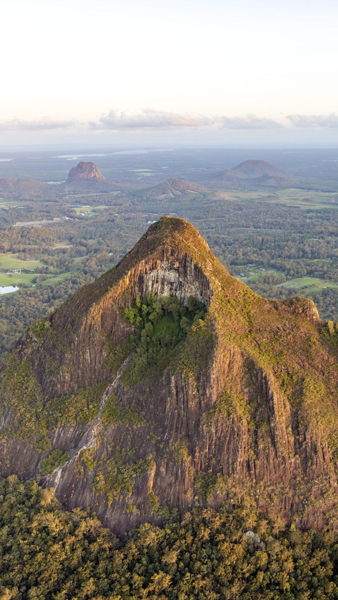 Glass House Mountain cliffs in golden light.