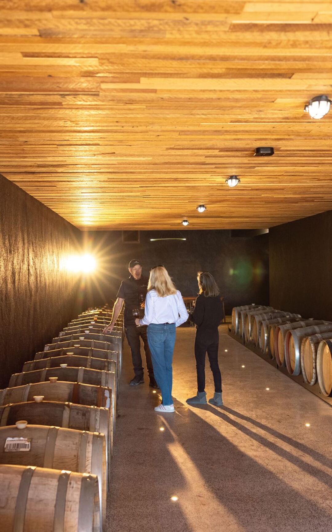 Guests in the barrel-lined wine cave at Meteora Vineyard.