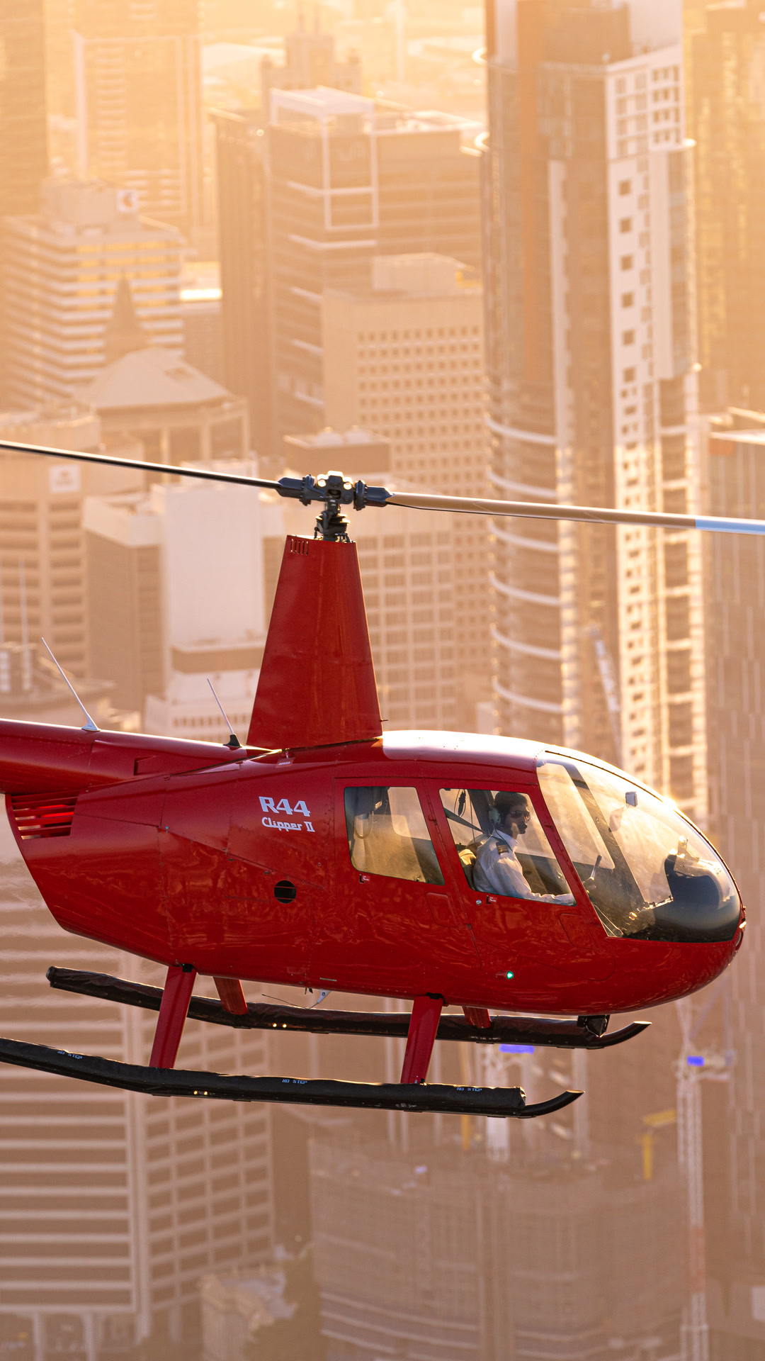 Red Bekaa Air helicopter flying over Brisbane in golden morning light.