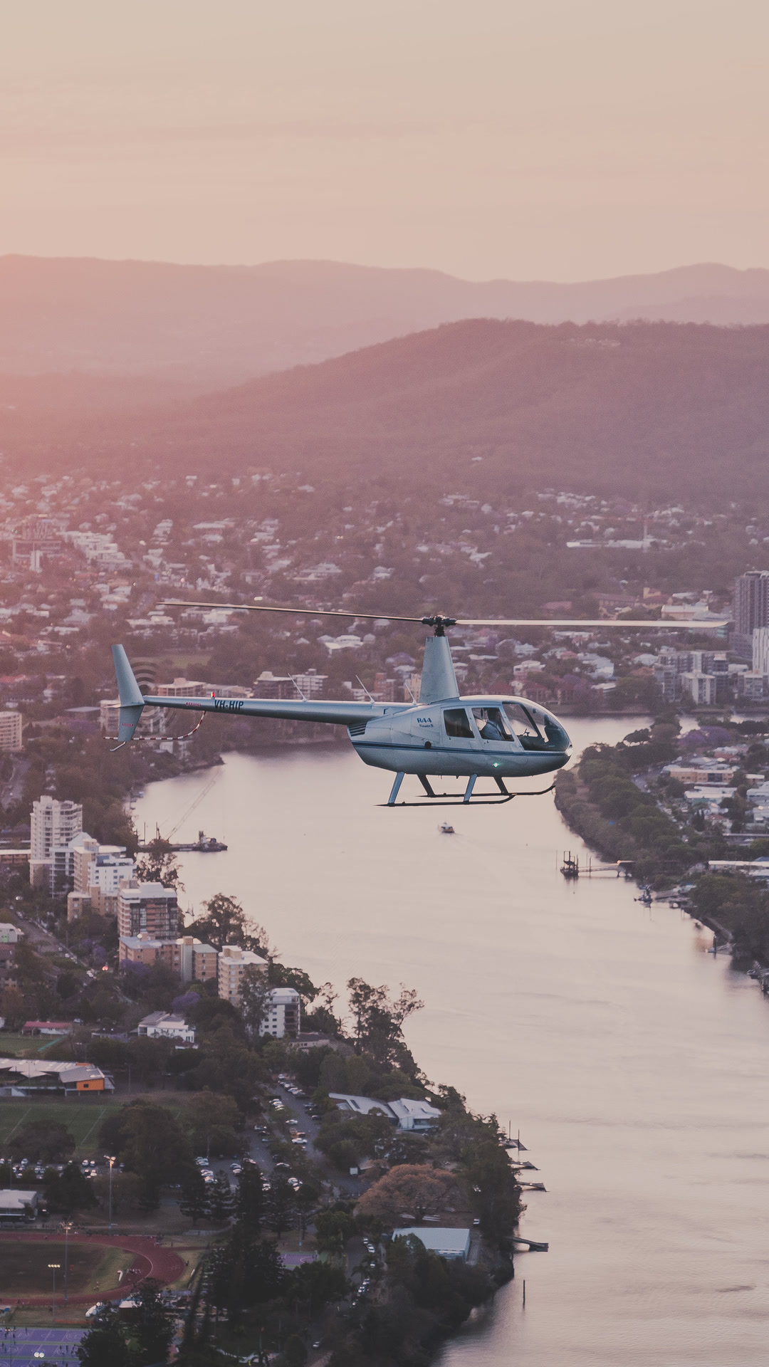 Helicopter over Brisbane River at sunrise.