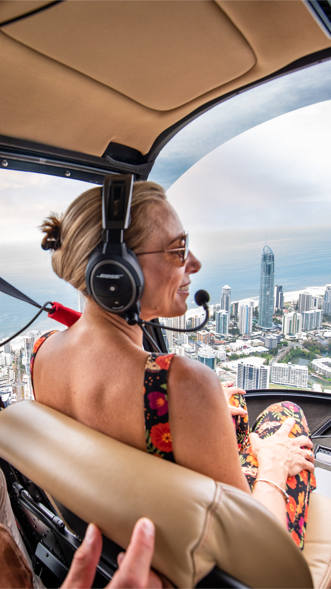 Passenger view from a helicopter cabin above the coastline and city.