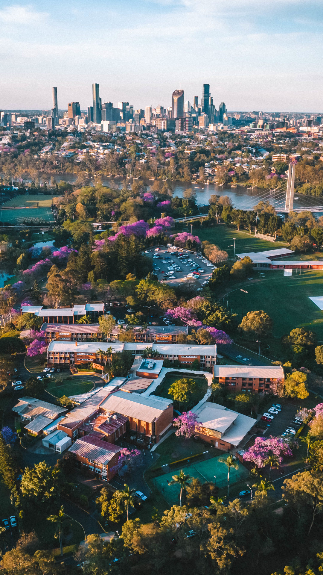 Aerial view across Brisbane suburbs toward the city skyline.