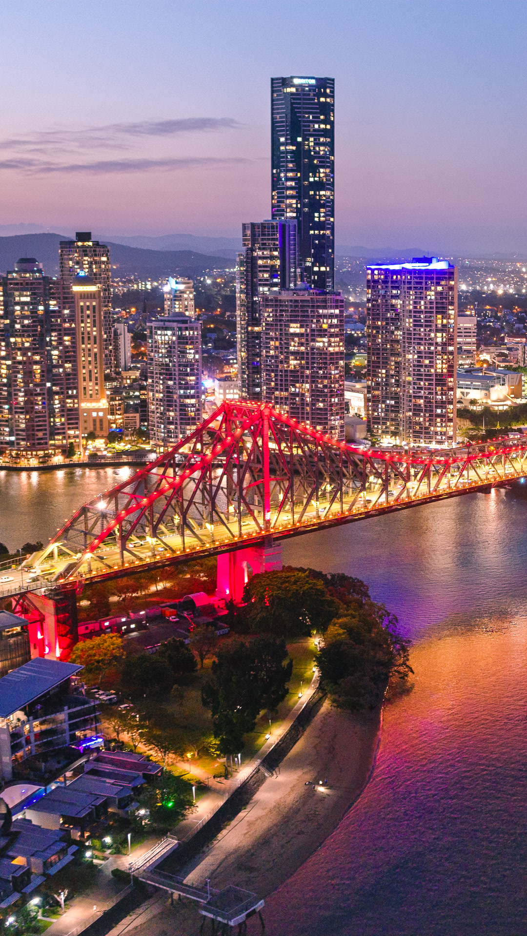 Aerial view of Brisbane River and Story Bridge at sunset.