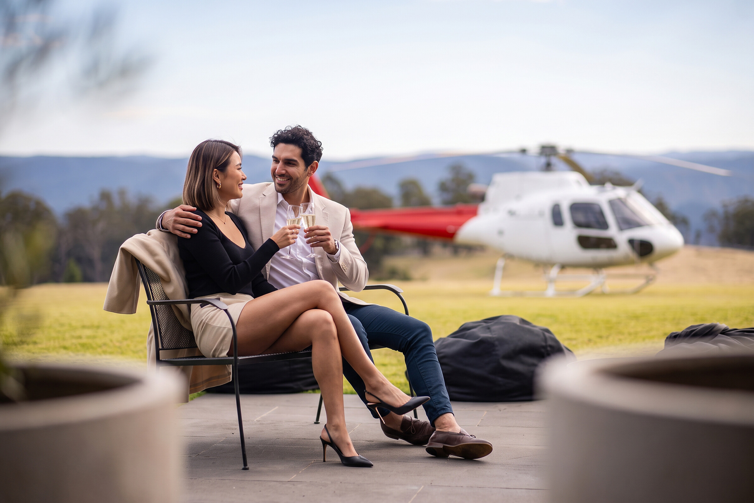 Guests relaxing at a lodge with a Bekaa Air helicopter nearby.