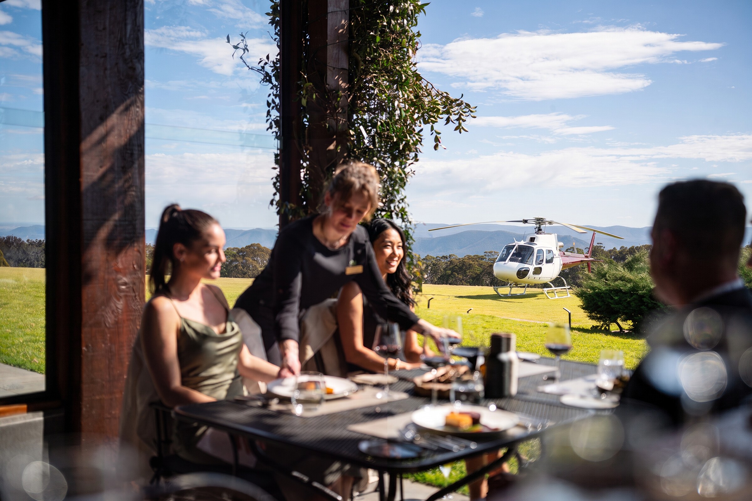 Guests enjoying lunch with a Bekaa Air helicopter on the lawn beyond the terrace.