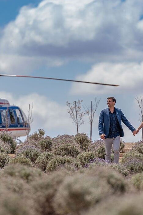 Couple walking through Kooroomba lavender fields after arriving by helicopter