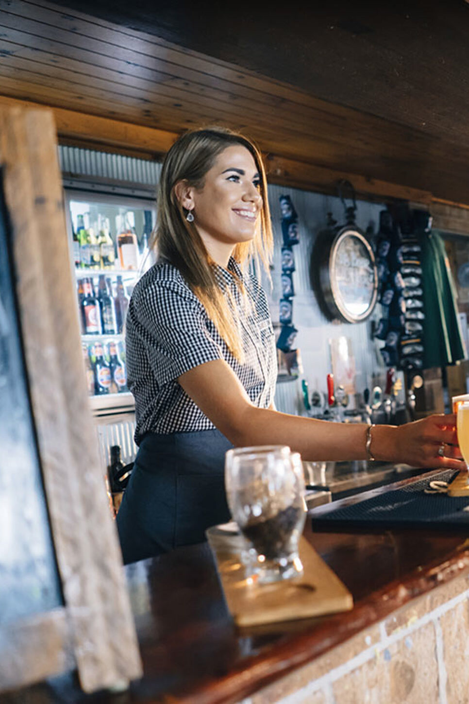 Woman serving drinks inside a coastal pub crawl backup venue