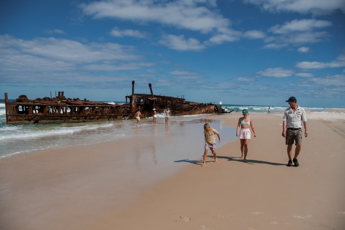Guide walking with a family past the Maheno Shipwreck