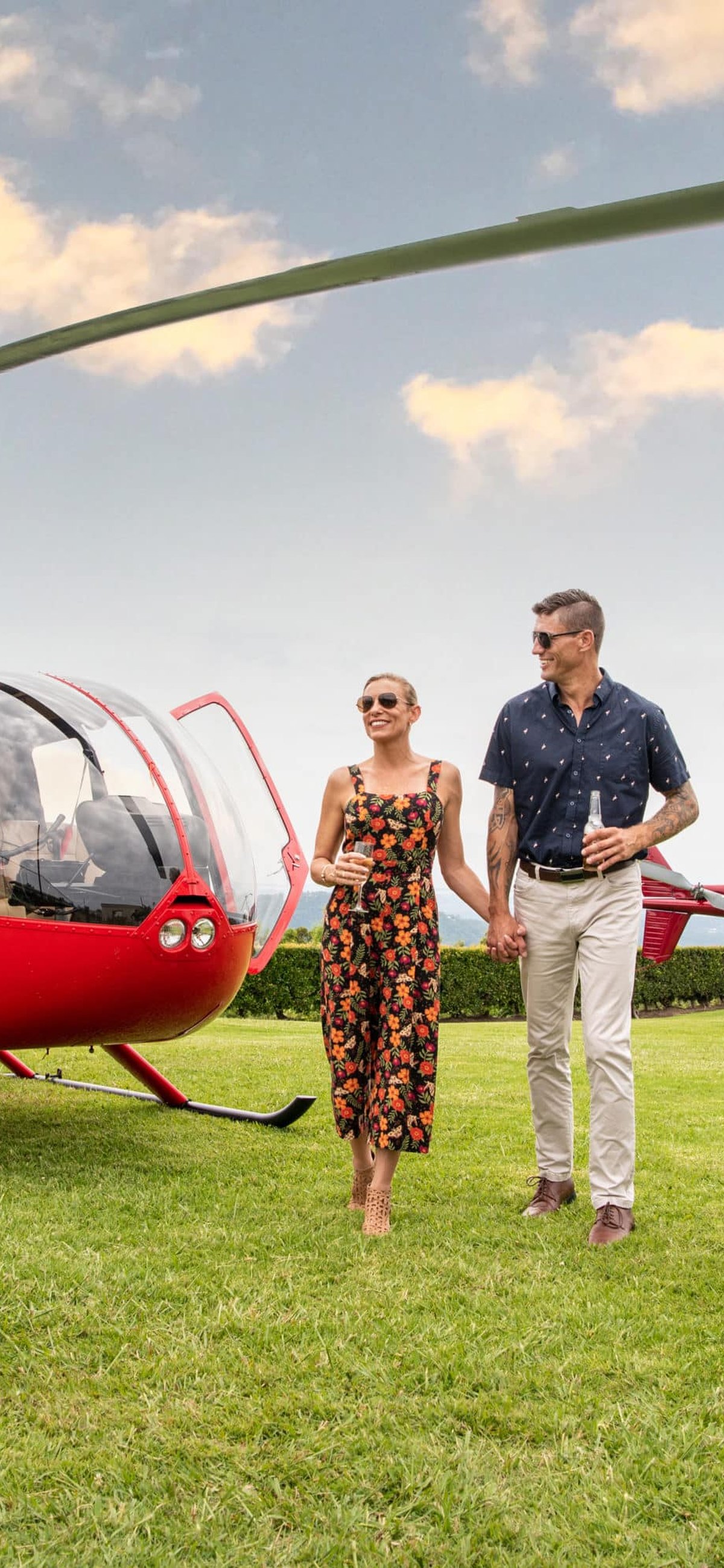 Guests beside a red helicopter on the Gold Coast and Brisbane pub crawl.