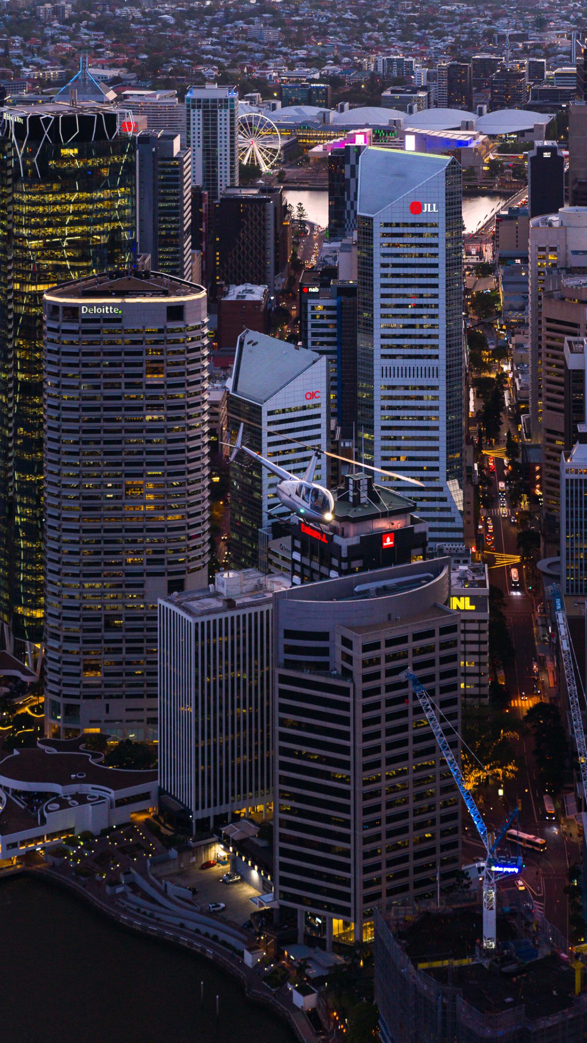 Bekaa Air helicopter flying between Brisbane city towers at dawn