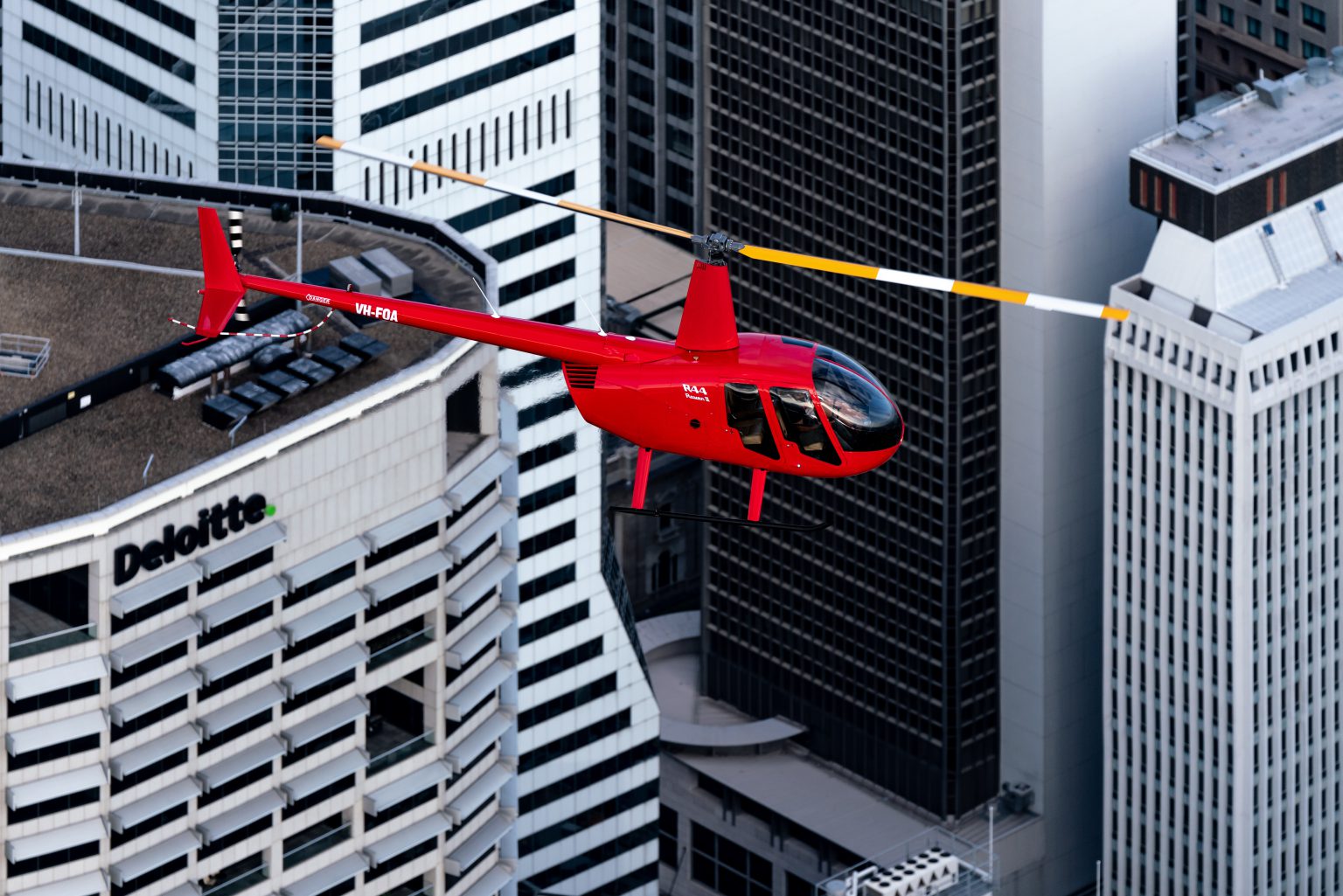 Red helicopter over Brisbane City from the Secrets scenic flight.