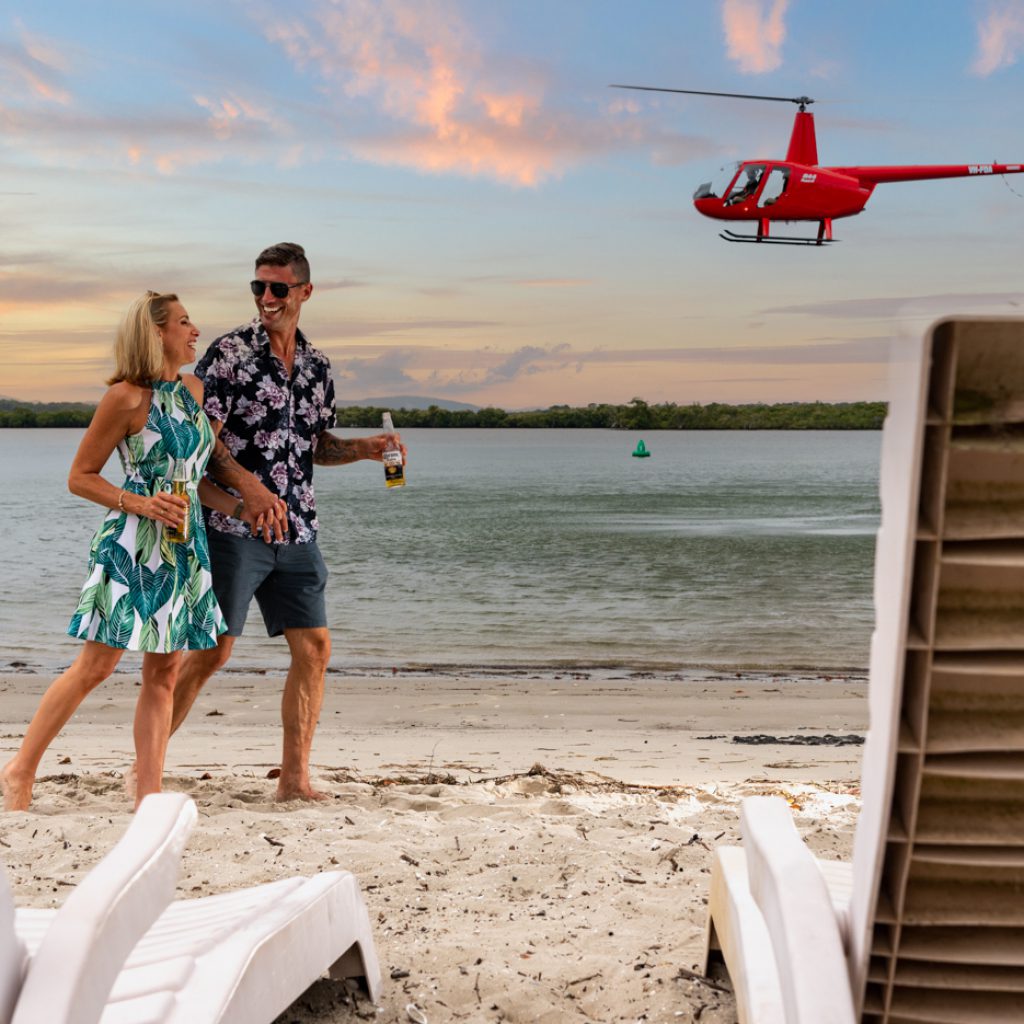 Wine and Stein guest beside the helicopter at sunset.