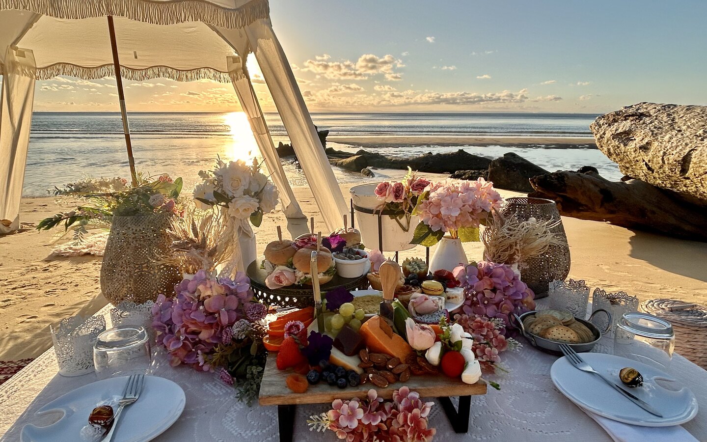 Signature beach picnic arranged in golden light.