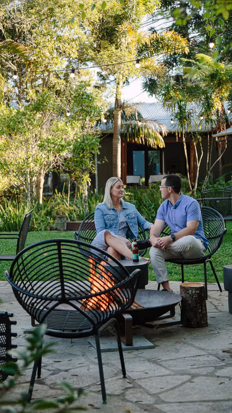 Guests relaxing by the garden fire pit at Spicers Tamarind.
