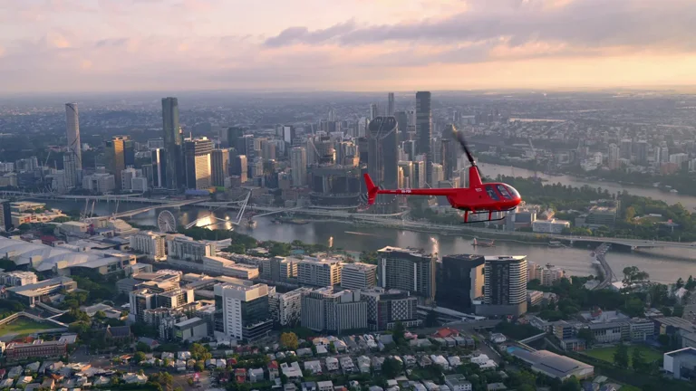 Bekaa Air Robinson R44 over Brisbane and the Brisbane River at sunset