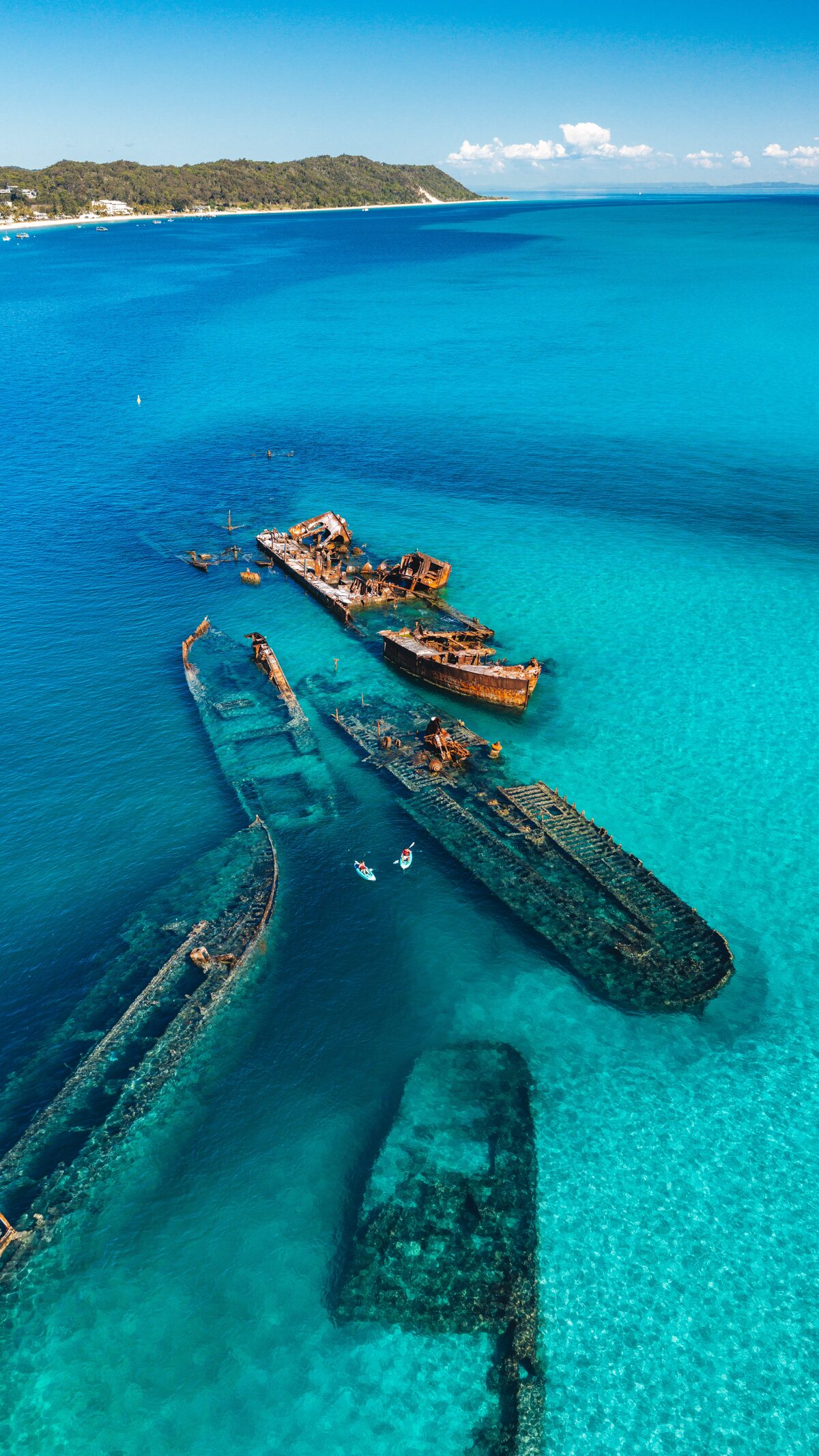 The Tangalooma Wrecks stretching through clear turquoise water.