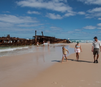 Guide walking with a family past the Maheno Shipwreck